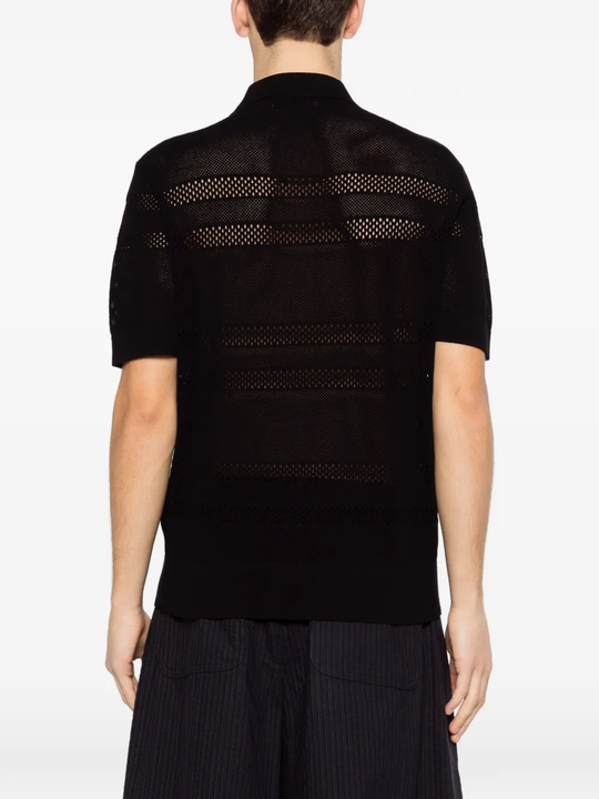 black knitwear worn by a person, showing the knitwear fit