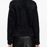 Black knitwear worn by a person, showing the knitwear fit