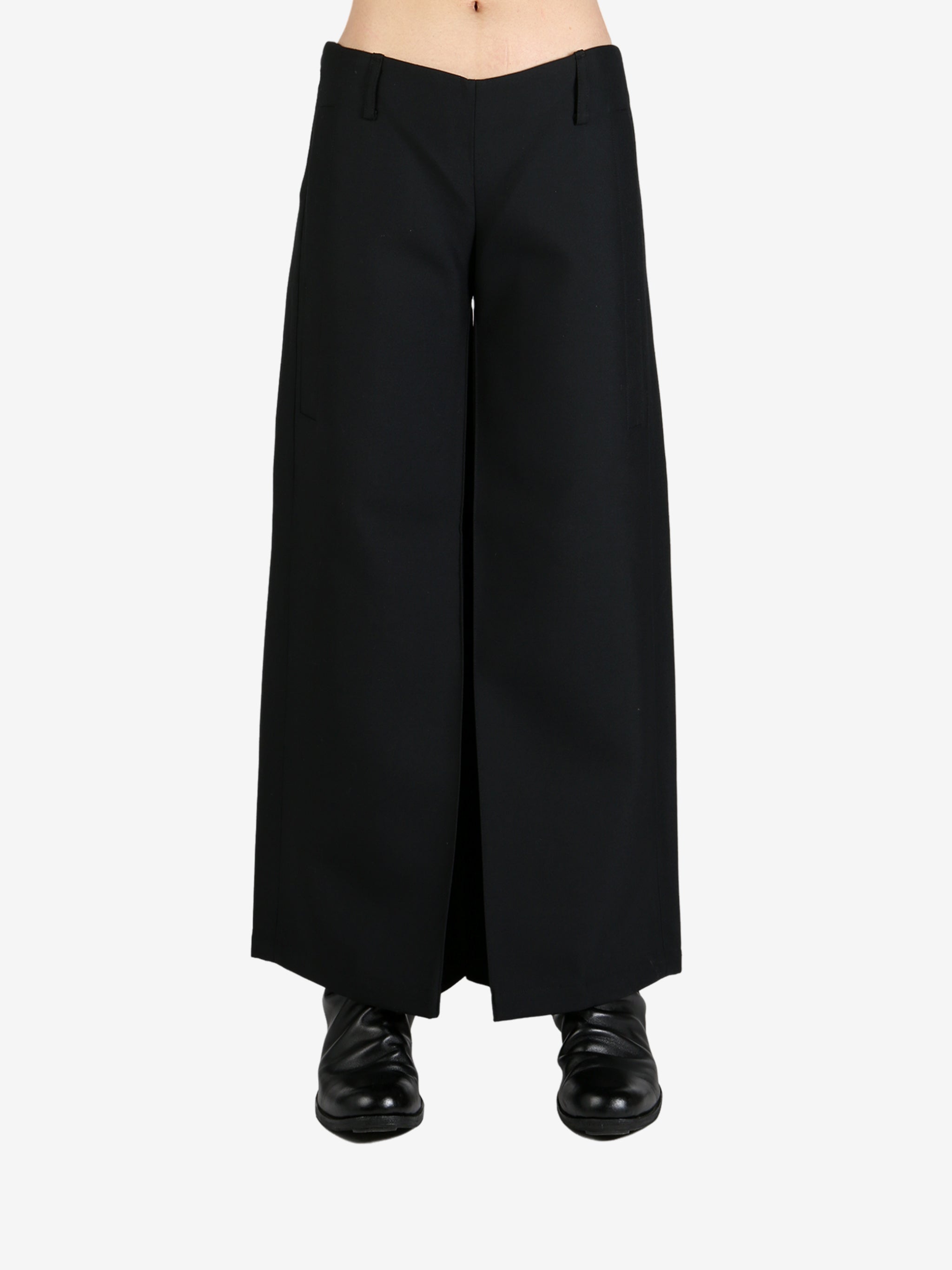 Black pants worn by a person, showing the pants's fit