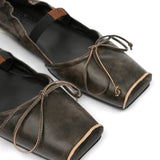 Close up of black flat, showing texture of the leather fabric