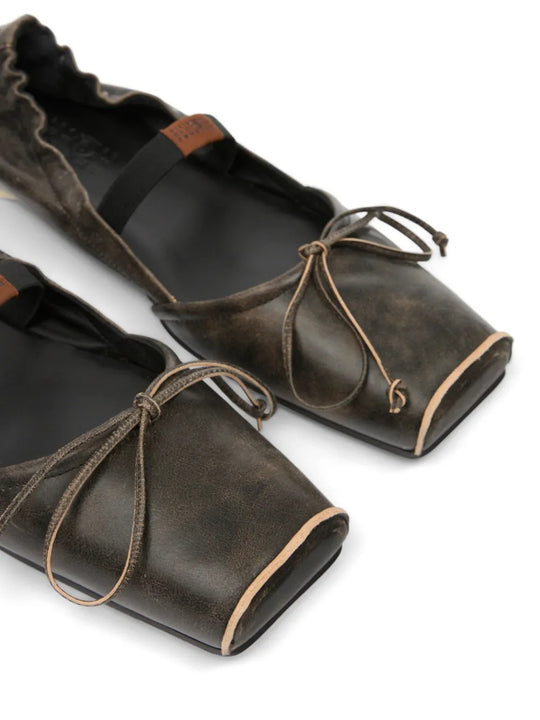Close up of black flat, showing texture of the leather fabric