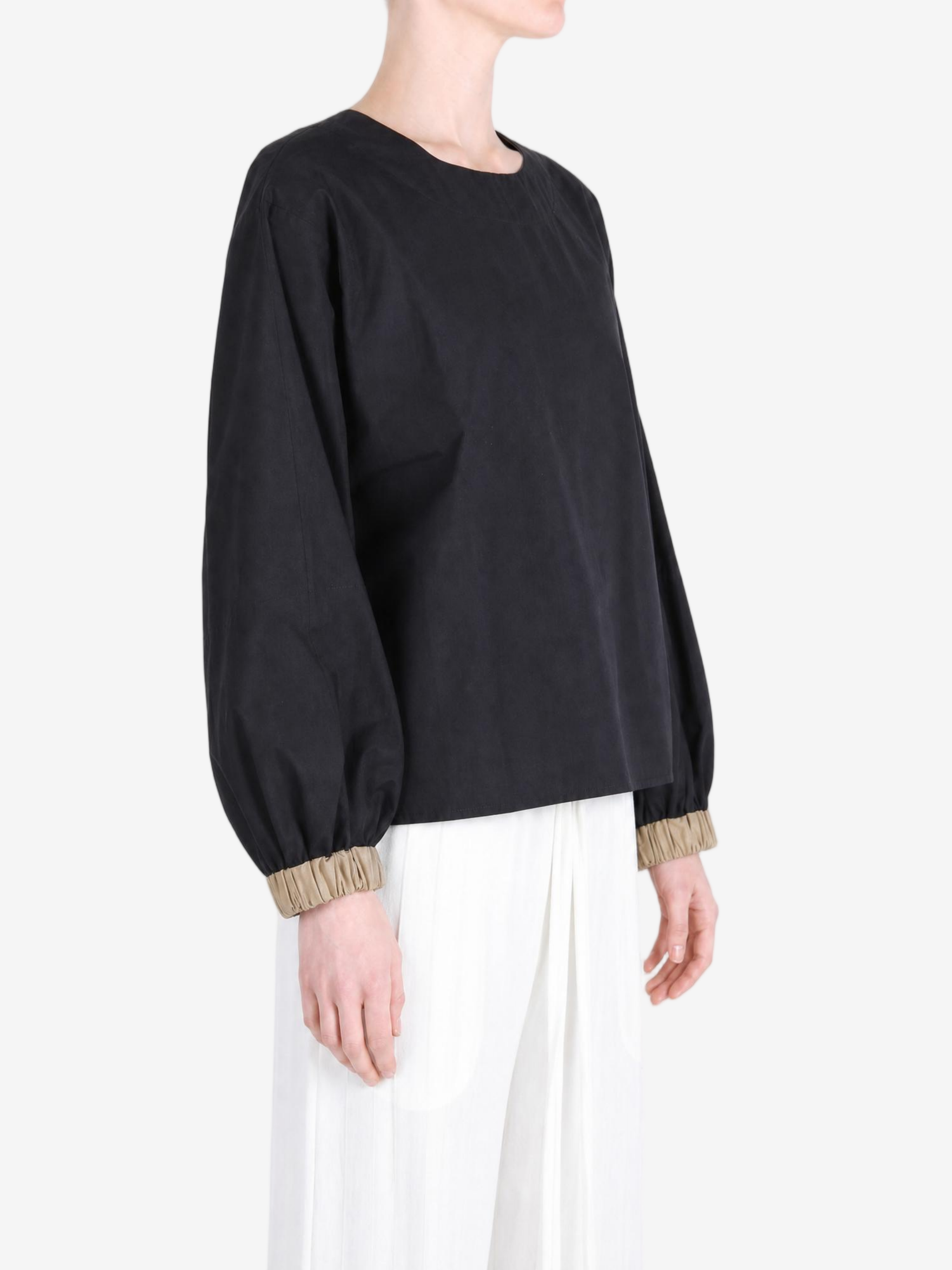 Black top worn by a person, showing the top fit