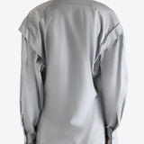 Grey blouse worn by a person, showing the blouse's fit