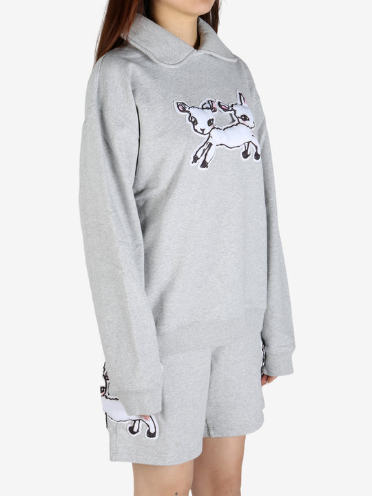 Grey knitwear worn by a person, showing the knitwear's fit