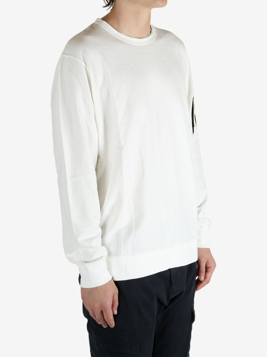 White crewneck worn by a person, showing the crewneck fit