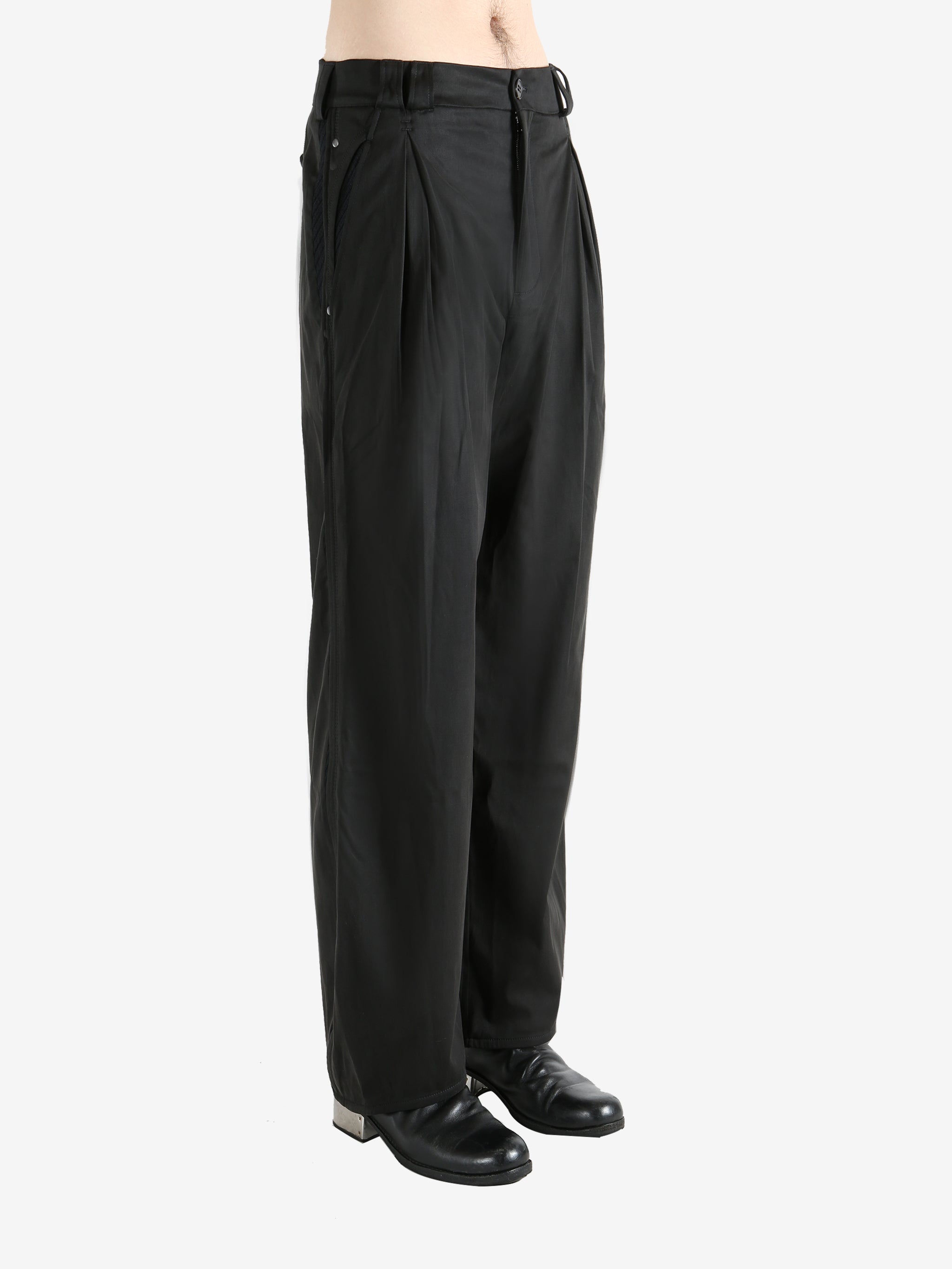 Black pants worn by a person, showing the pants' fit