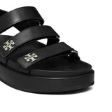 Close up of the black sandal, showing texture of the leather fabric