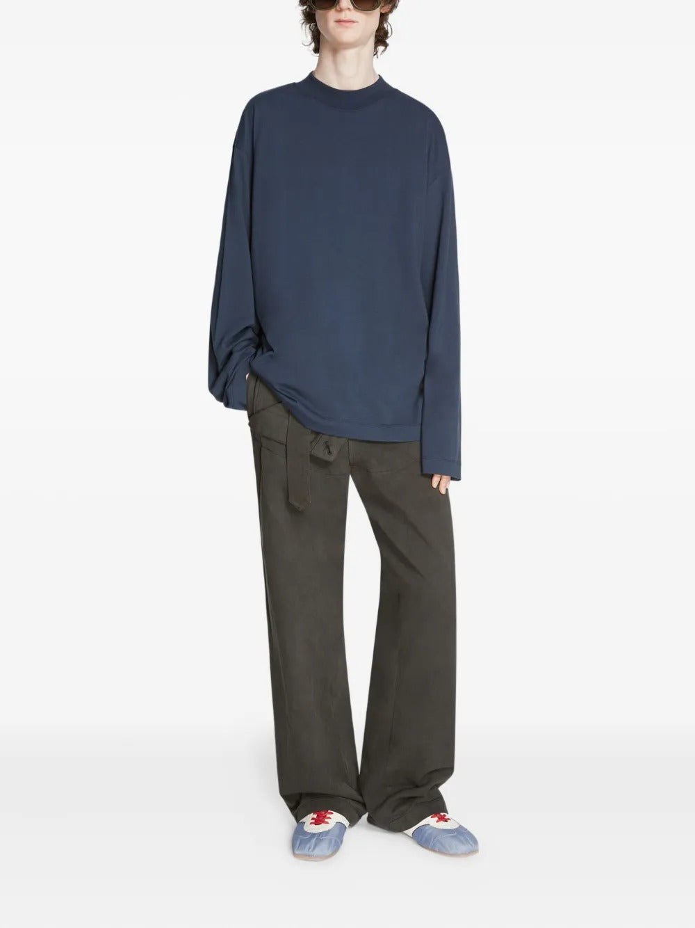 Blue sneakers worn by a person, showing the sneakers' fit