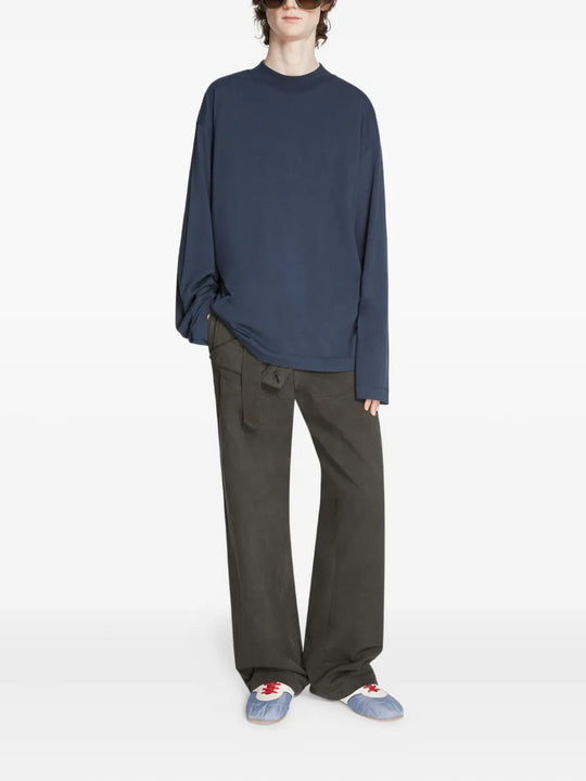 Blue sneakers worn by a person, showing the sneakers' fit