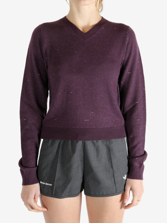 Purple knitwear worn by a person, showing the knitwear fit