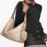 Beige bag carried by a person, showing the bag fit