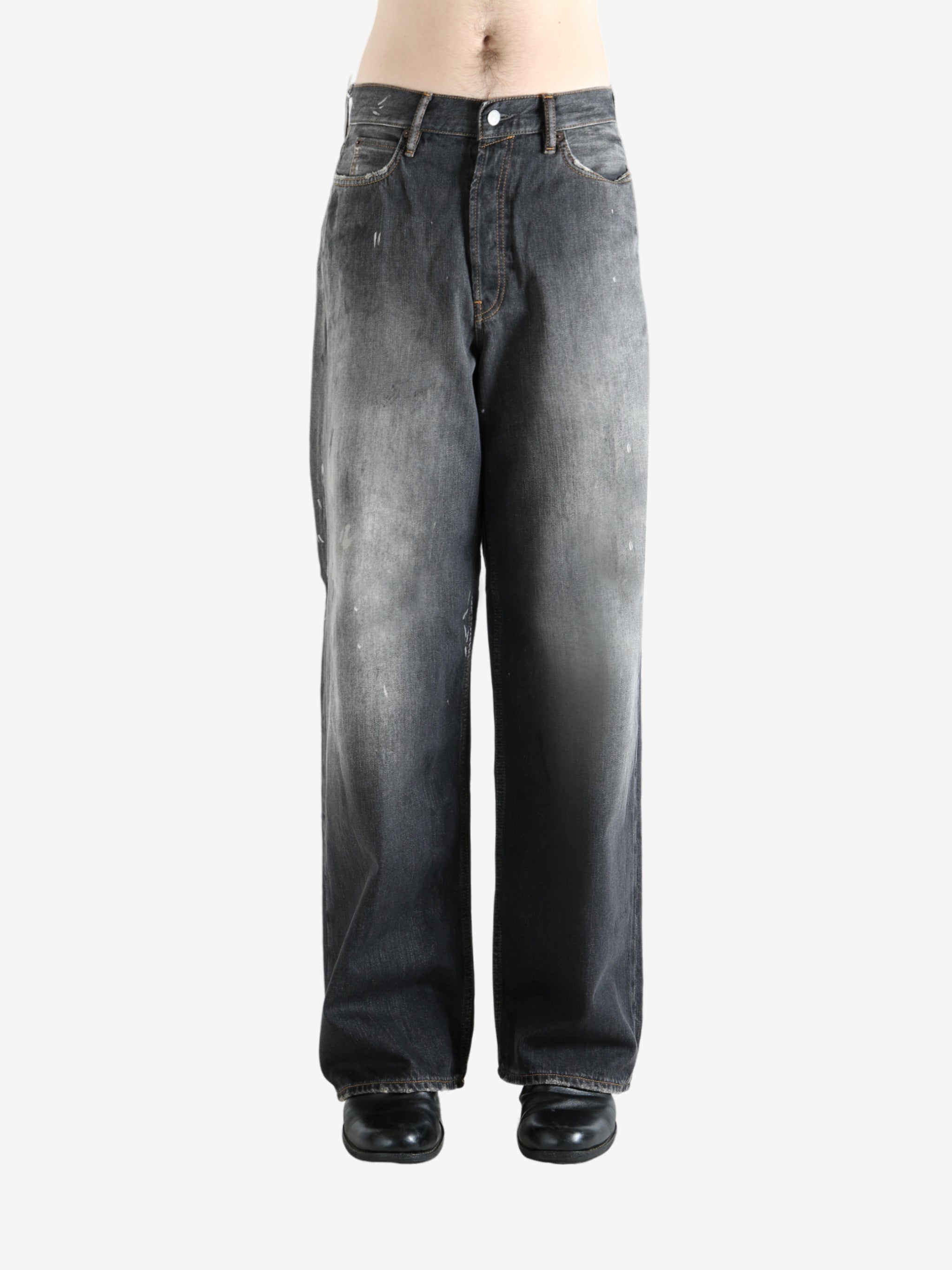 Black jeans worn by a person, showing the jeans' fit