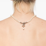 White necklace worn by a person, showing the necklace's fit