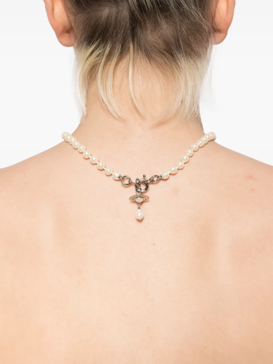 White necklace worn by a person, showing the necklace's fit