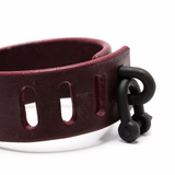 Close up of red bracelet, showing texture of the leather fabric