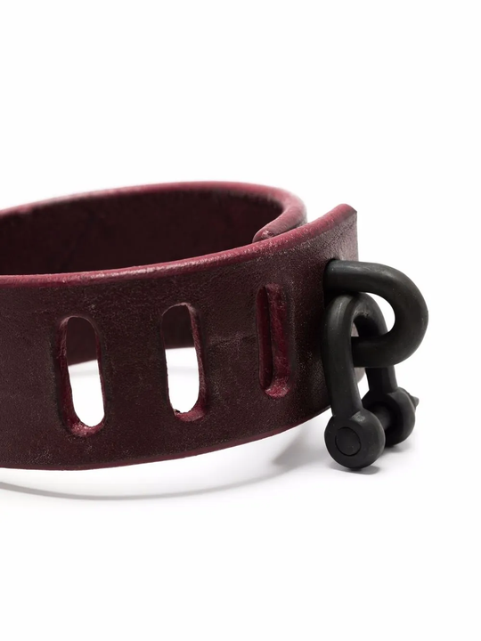 Close up of red bracelet, showing texture of the leather fabric