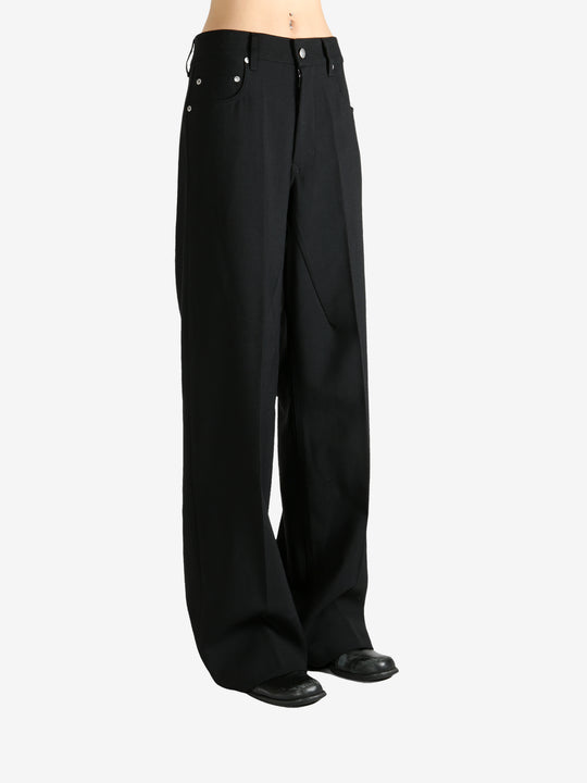 Black pants worn by a person, showing the pants fit