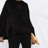 Black knitwear worn by a person, showing the knitwear fit