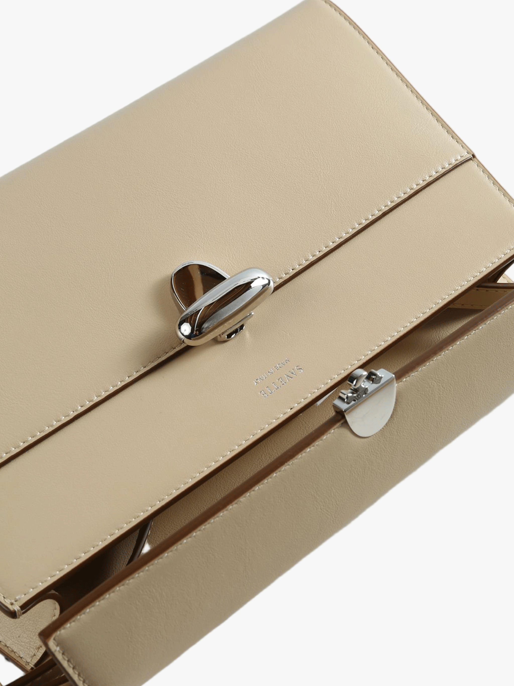 Close up of beige bag, showing the detial of the buckle