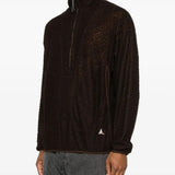 Brown knitwear worn by a person, showing the knitwear's fit