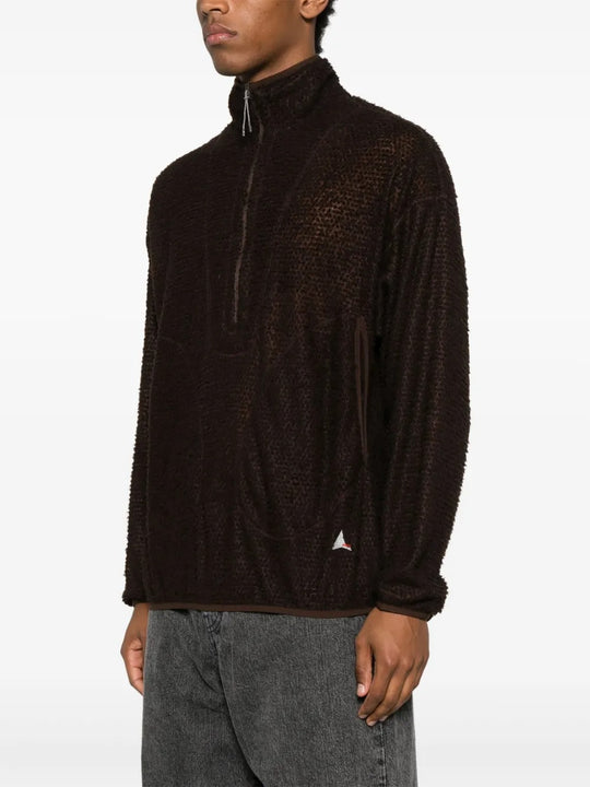 Brown knitwear worn by a person, showing the knitwear's fit