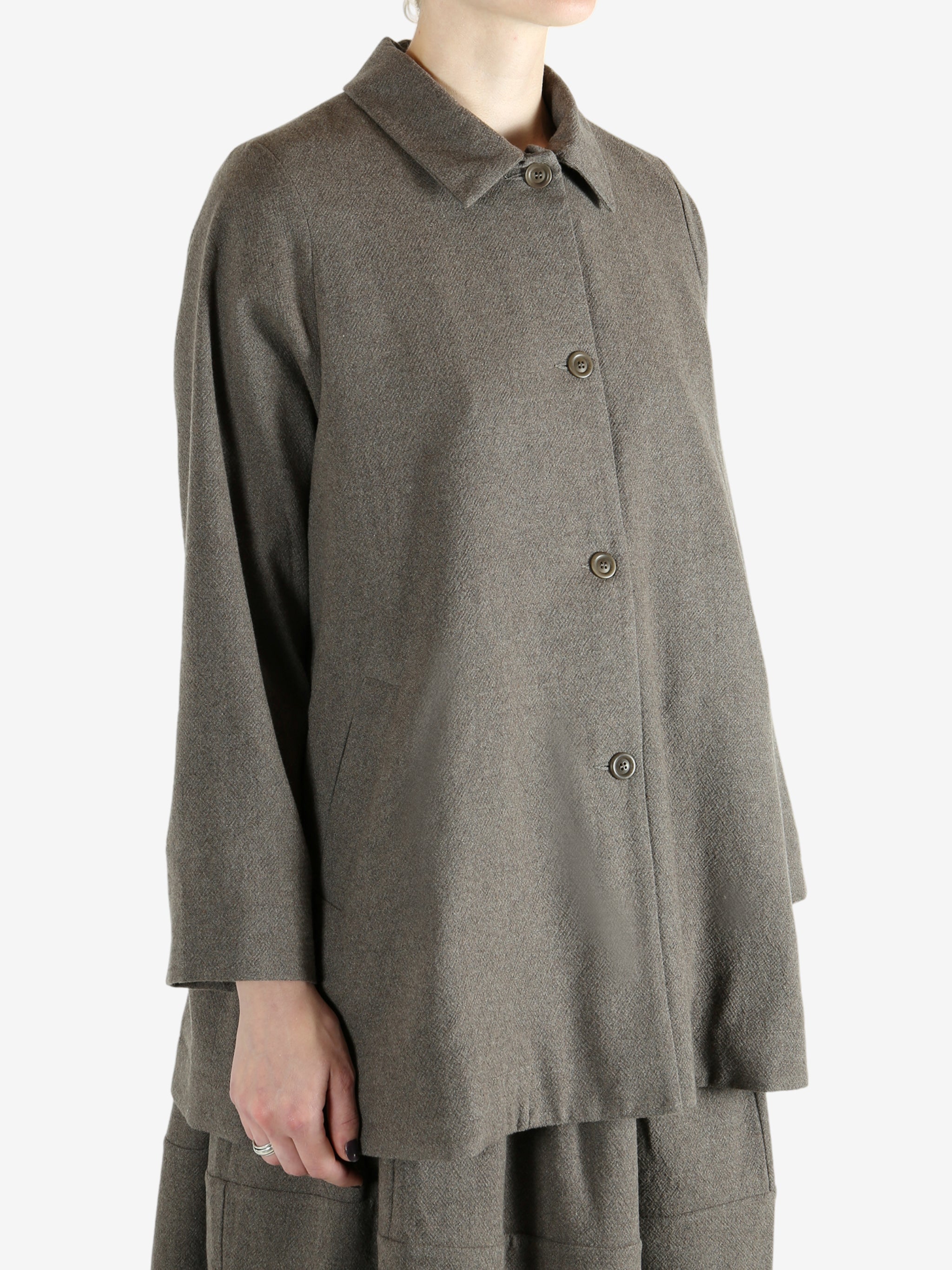 Grey coat worn by a person, showing the coat fit