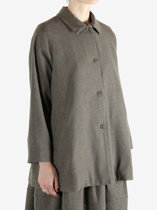 Grey coat worn by a person, showing the coat fit