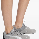 Grey sneakers worn by a person, showing the sneakers's fit
