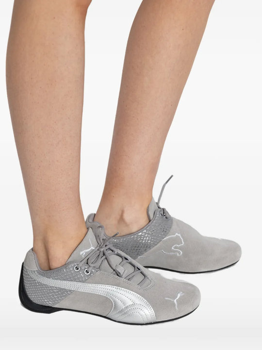 Grey sneakers worn by a person, showing the sneakers's fit