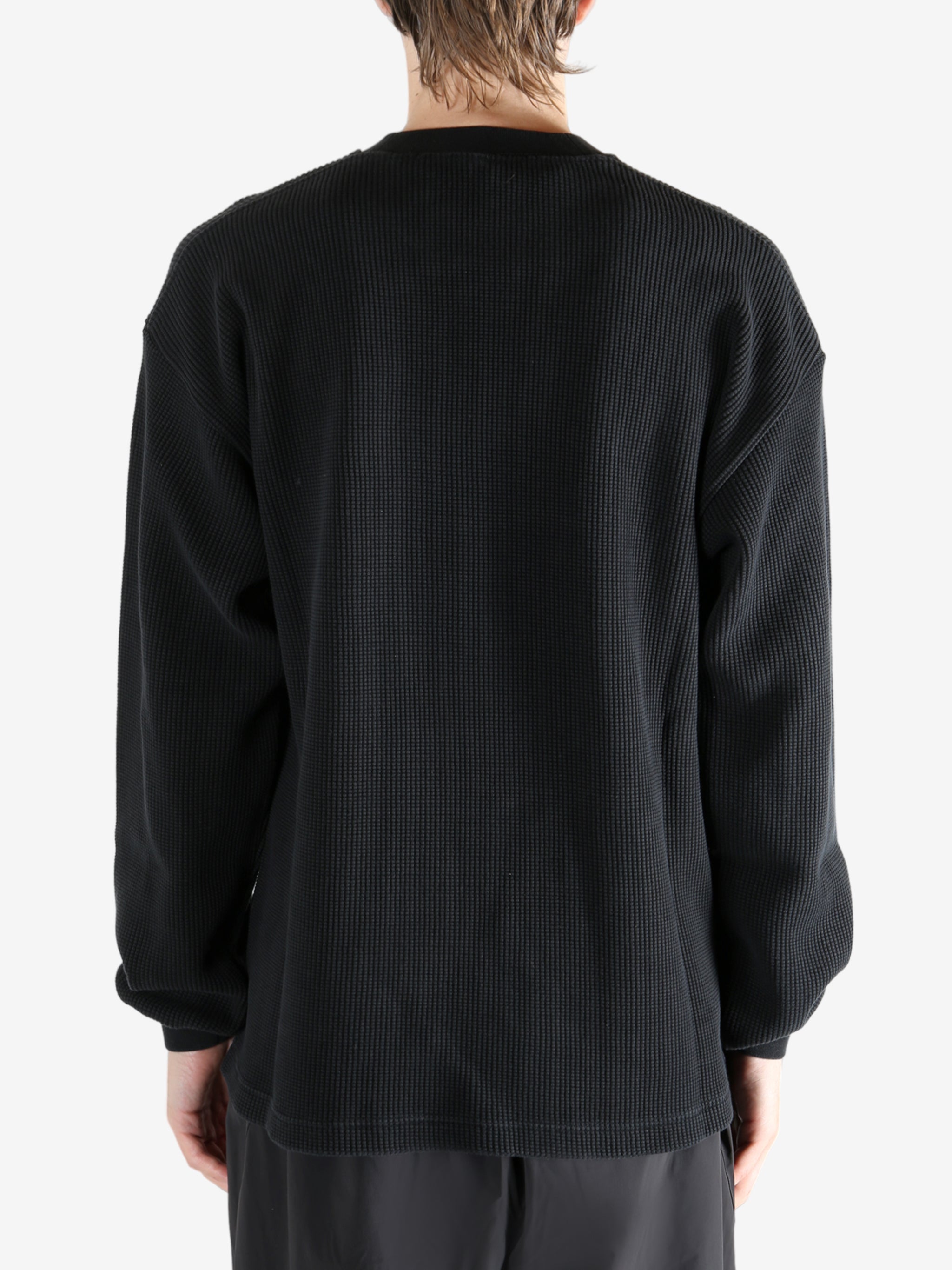 Black t-shirt worn by a person, showing the t-shirt's fit