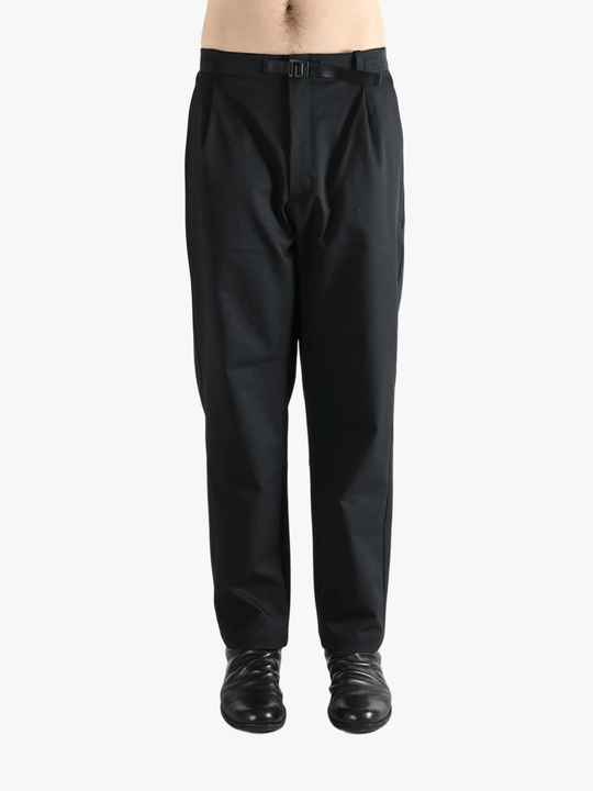 Black pants worn by a person, showing the pants' fit
