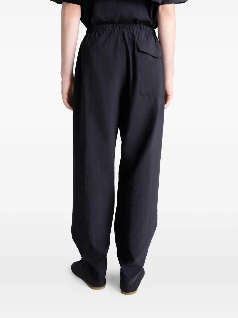 Black pants worn by a person, showing the pants' fit