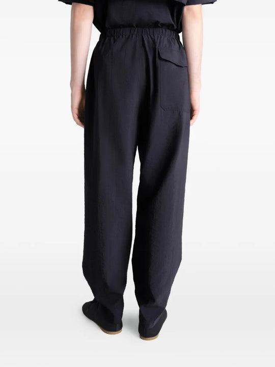 Black pants worn by a person, showing the pants' fit