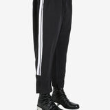 Black pants worn by a person, showing the pant’s fit