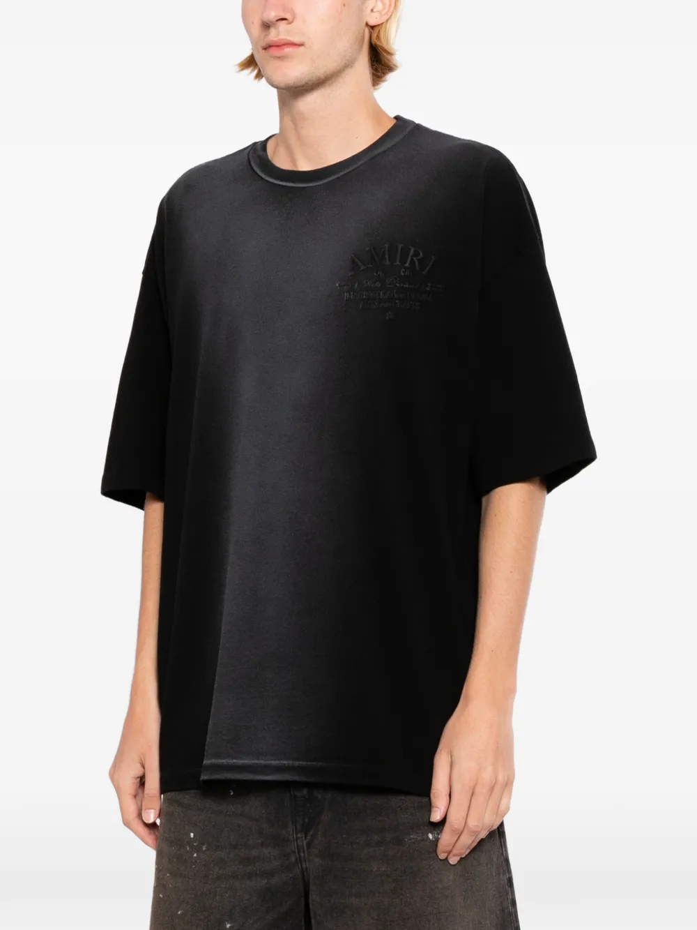 Black T-shirts worn by a person, showing the T-shirts' fit