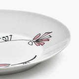 Close up of pink plate, showing texture of the bone porcelain fabric