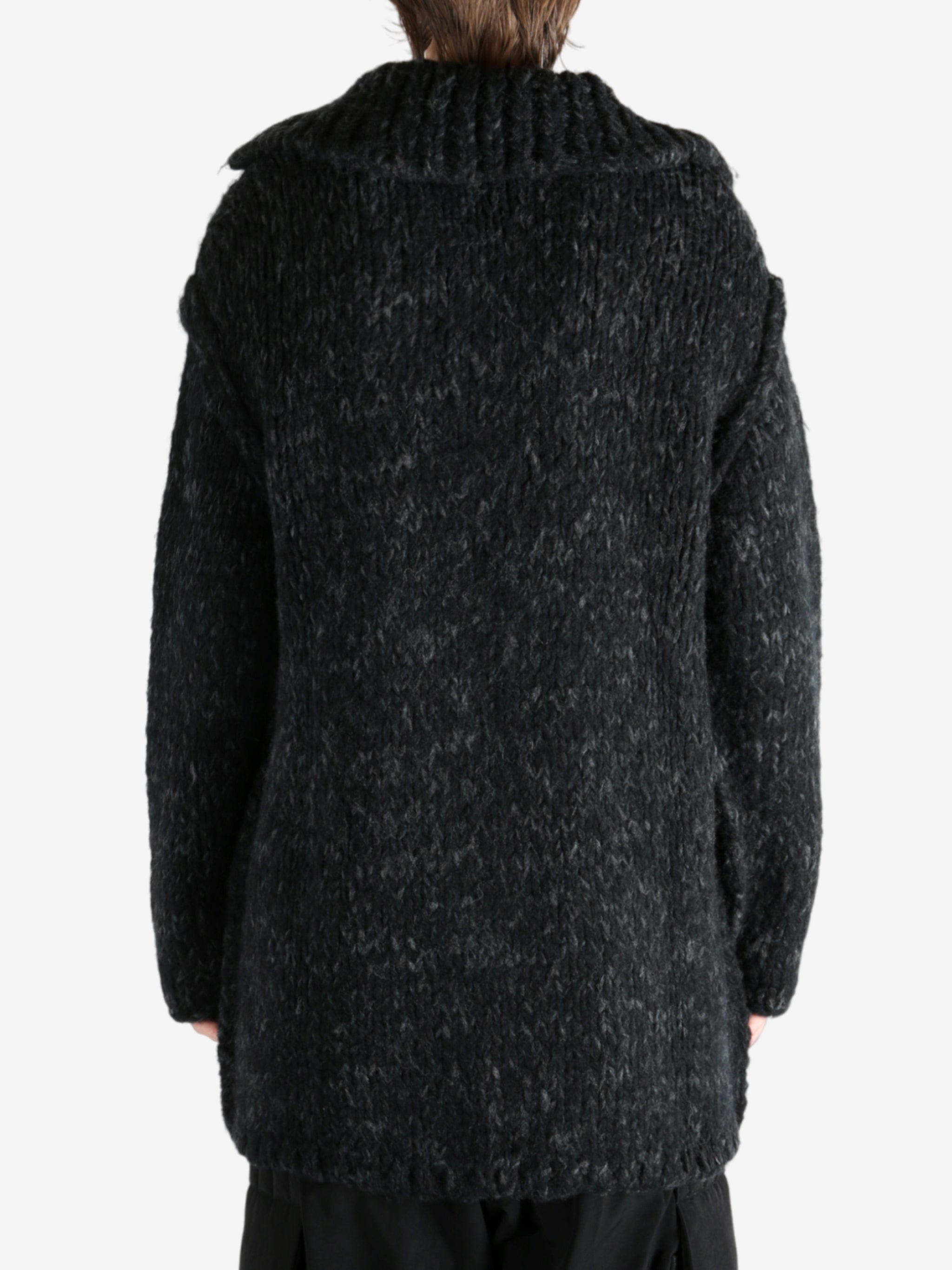 Black coat worn by a person, showing the coat's fit