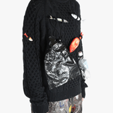 Black knitwear worn by a person, showing the knitwear's fit