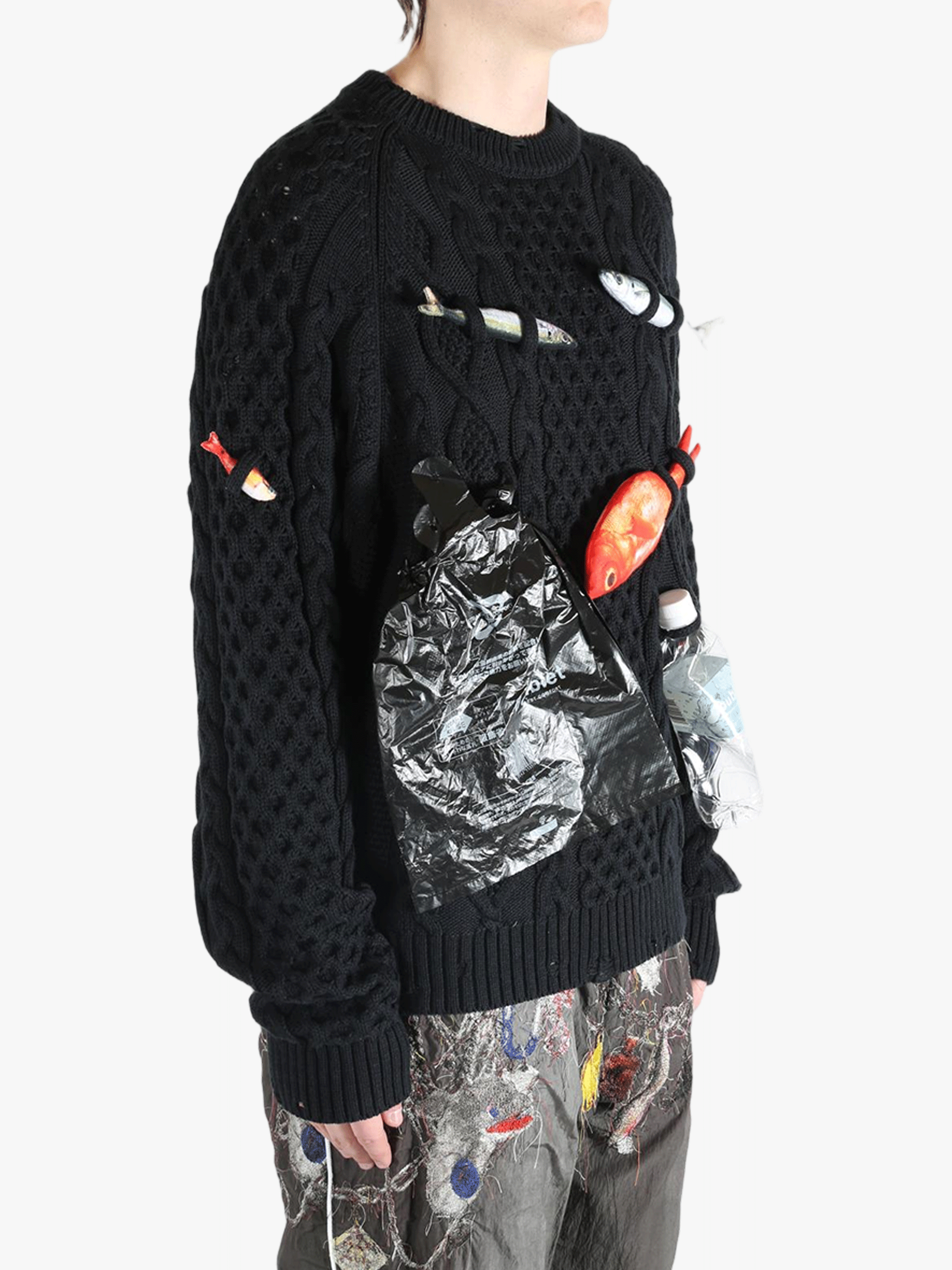 Black knitwear worn by a person, showing the knitwear's fit