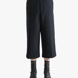 Black pants worn by a person, showing the pants's fit