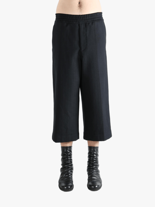 Black pants worn by a person, showing the pants's fit