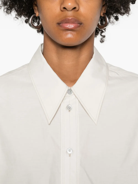 Close up of white shirt, showing the buttom detail of the collar