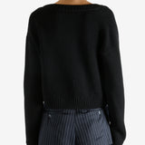 Black cardigan worn by a person, showing the cardigan’s fit