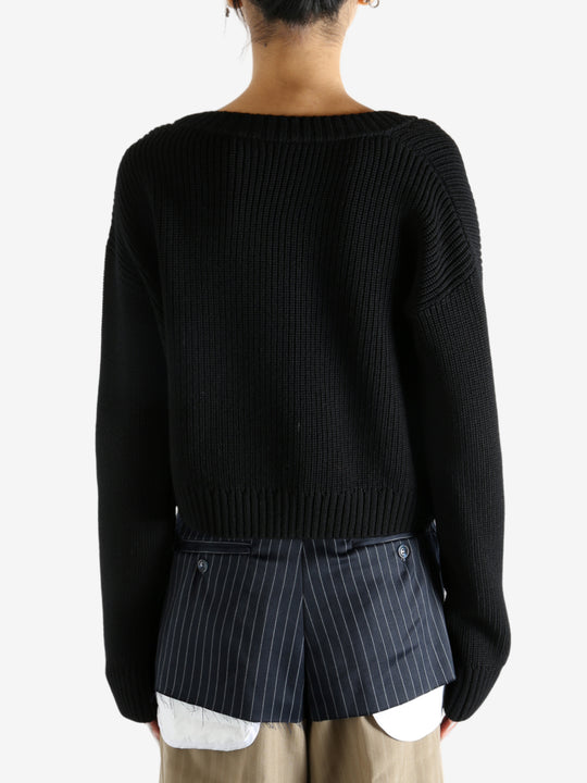 Black cardigan worn by a person, showing the cardigan’s fit