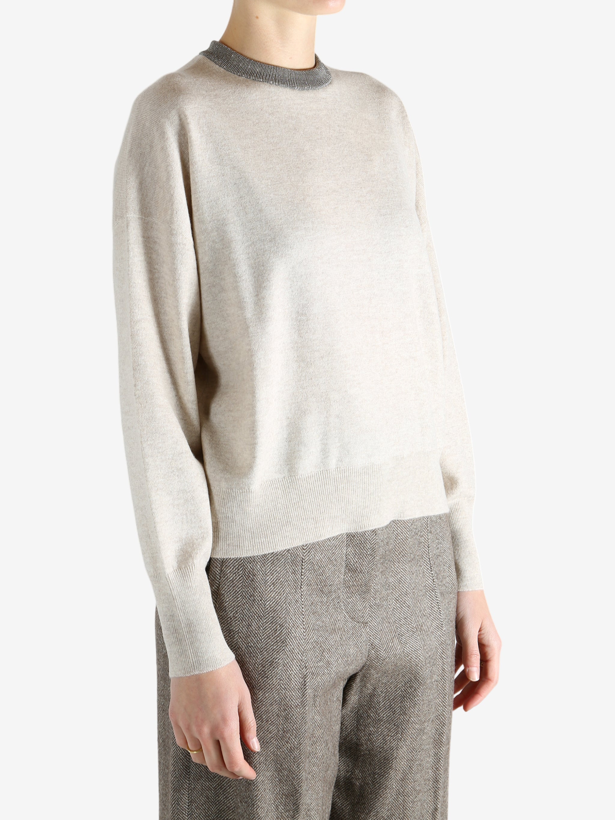 Grey knitwear worn by a person, showing the knitwear fit