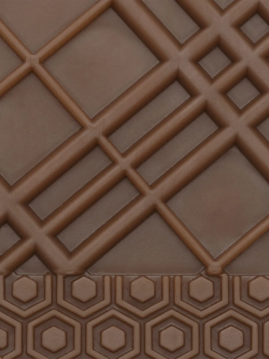 Close up of  tan sneakers, showing texture of the rubber fabric