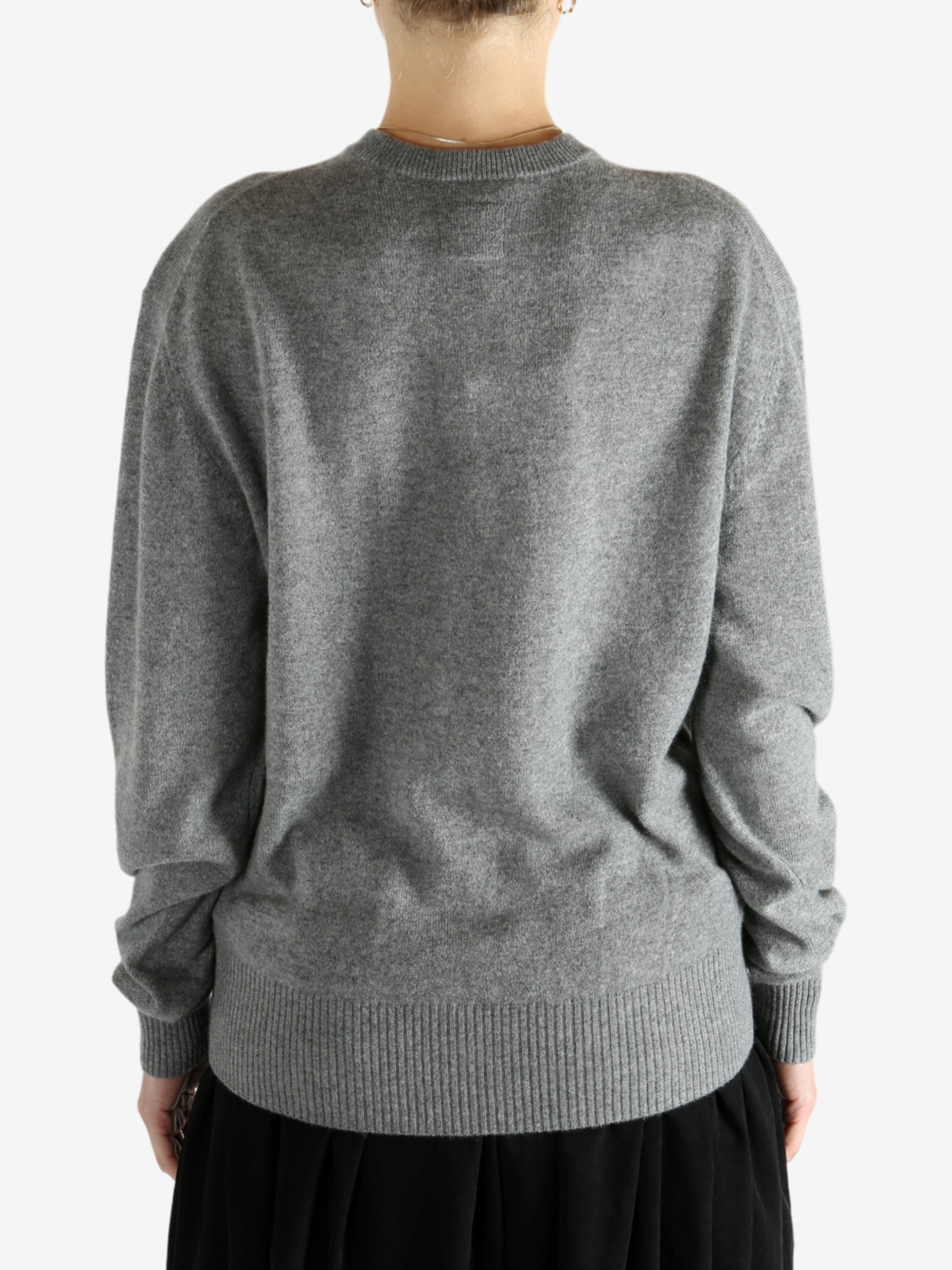 Grey knitwear worn by a person, showing the knitwear fit
