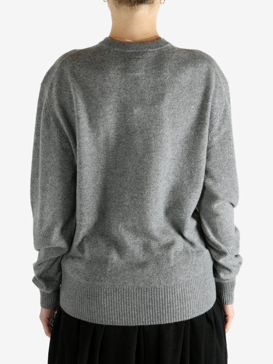 Grey knitwear worn by a person, showing the knitwear fit
