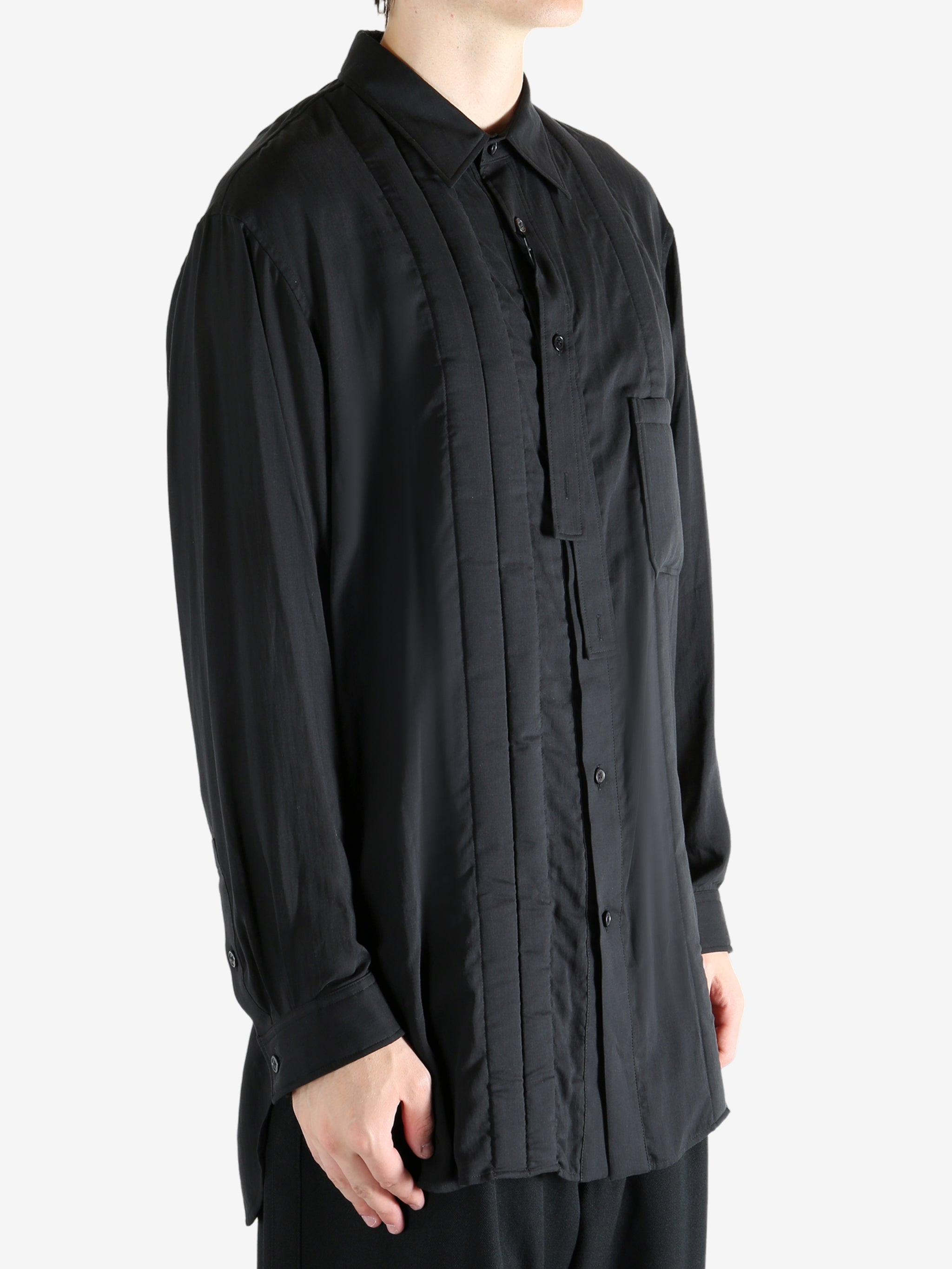 Black shirt worn by a person, showing the shirt's fit