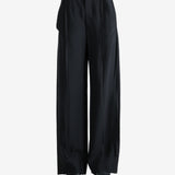 Black pants worn by a person, showing the pants' fit